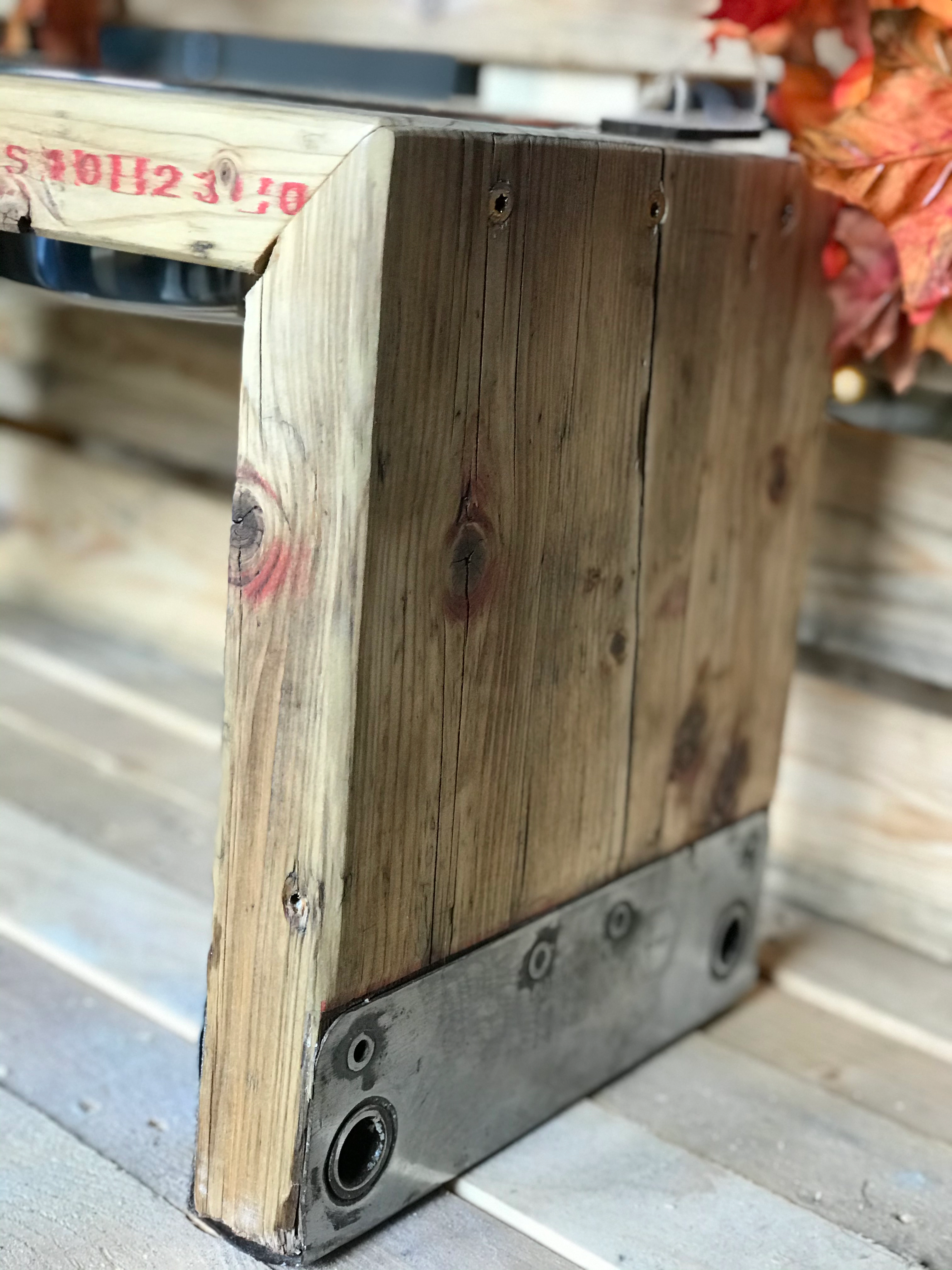 Nahaufnahme eines Holzstücks mit Metallplatte und Schrauben an der Unterseite